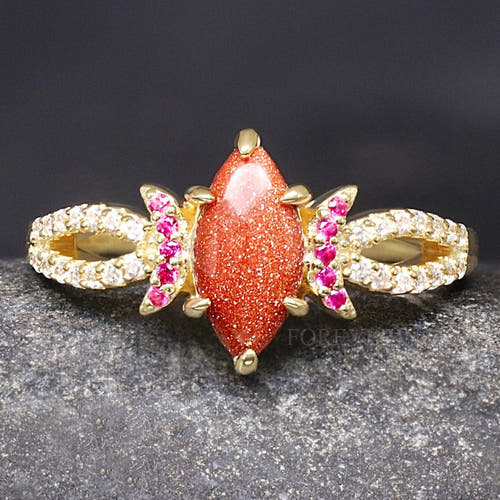 Women's gold sterling silver ring with a marquise red sandstone and ruby crescent moons, close front view