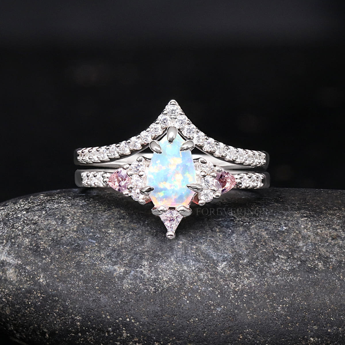 Women's sterling silver white opal engagement ring with pink side stones and curved band, front view