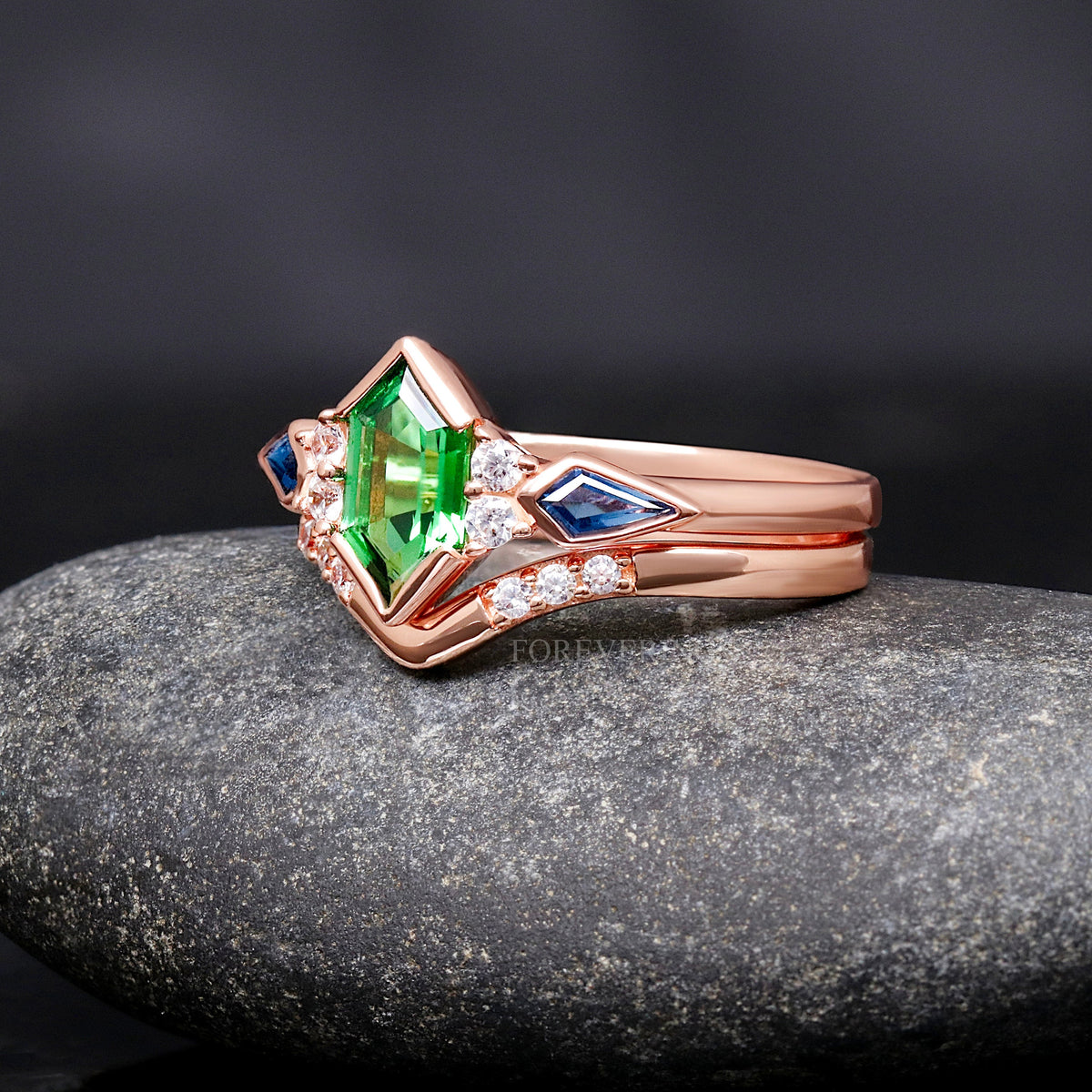 Rose gold sterling silver tsavorite engagement ring with a curved accent band, angled view