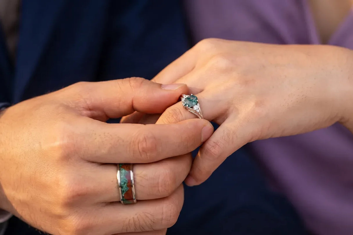 Couple wearing matching nature inspired rings, her moss agate ring and his inlay band