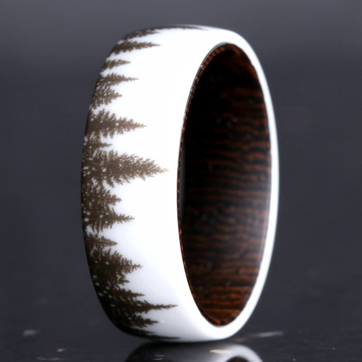 Men's white ceramic wedding band with a forest tree-line design and dark wood interior