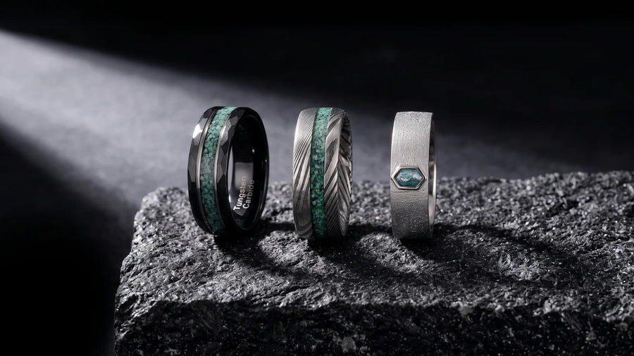 Most durable ring metals compared: tungsten carbide, damascus steel, and sterling silver men's rings on dark stone