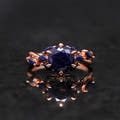 Oval blue sandstone engagement ring in rose gold shown straight on, reflection below