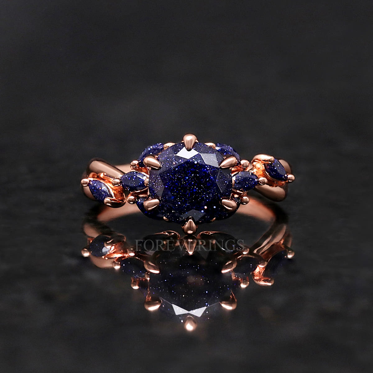 Oval blue sandstone engagement ring in rose gold shown straight on, reflection below