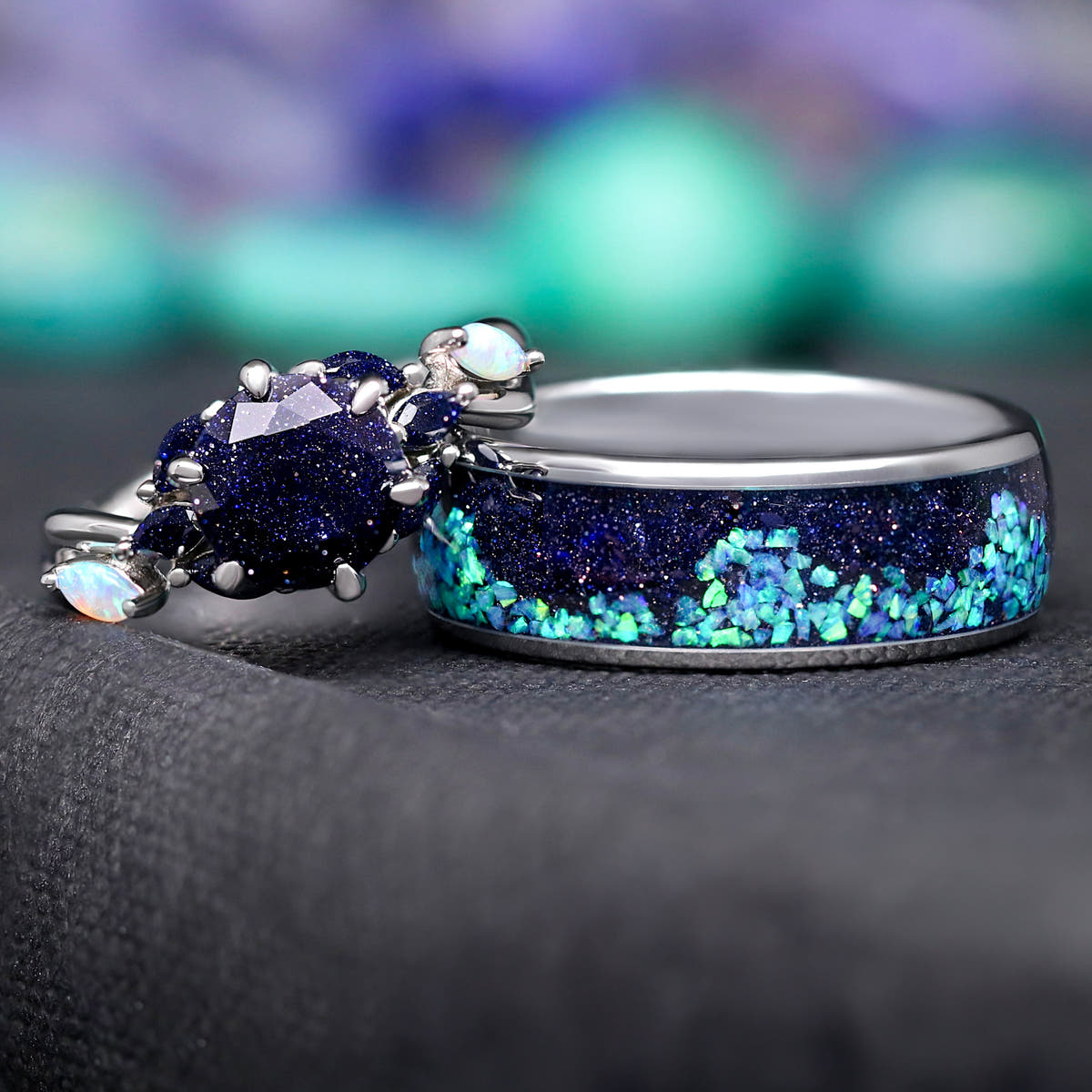 Blue sandstone engagement ring leaning on a wider band with blue opal inlay