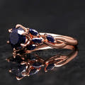 Women's rose gold sterling silver oval blue sandstone ring with leaf accents, close angled view