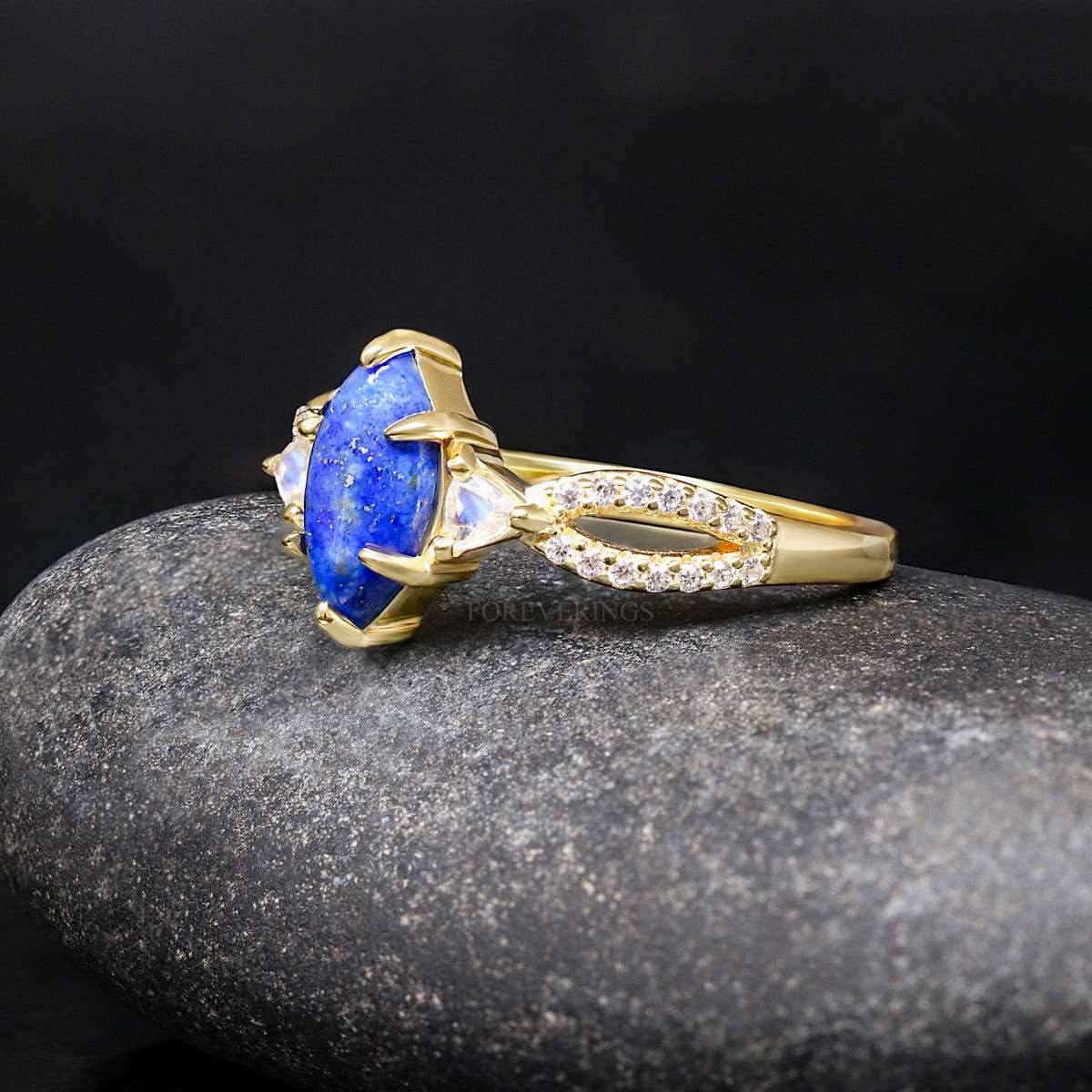 Gold sterling silver lapis lazuli engagement ring with moonstone side stones, angled side view