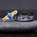 Gold lapis lazuli engagement ring beside a hammered black tungsten band with lapis and gold leaf inlay