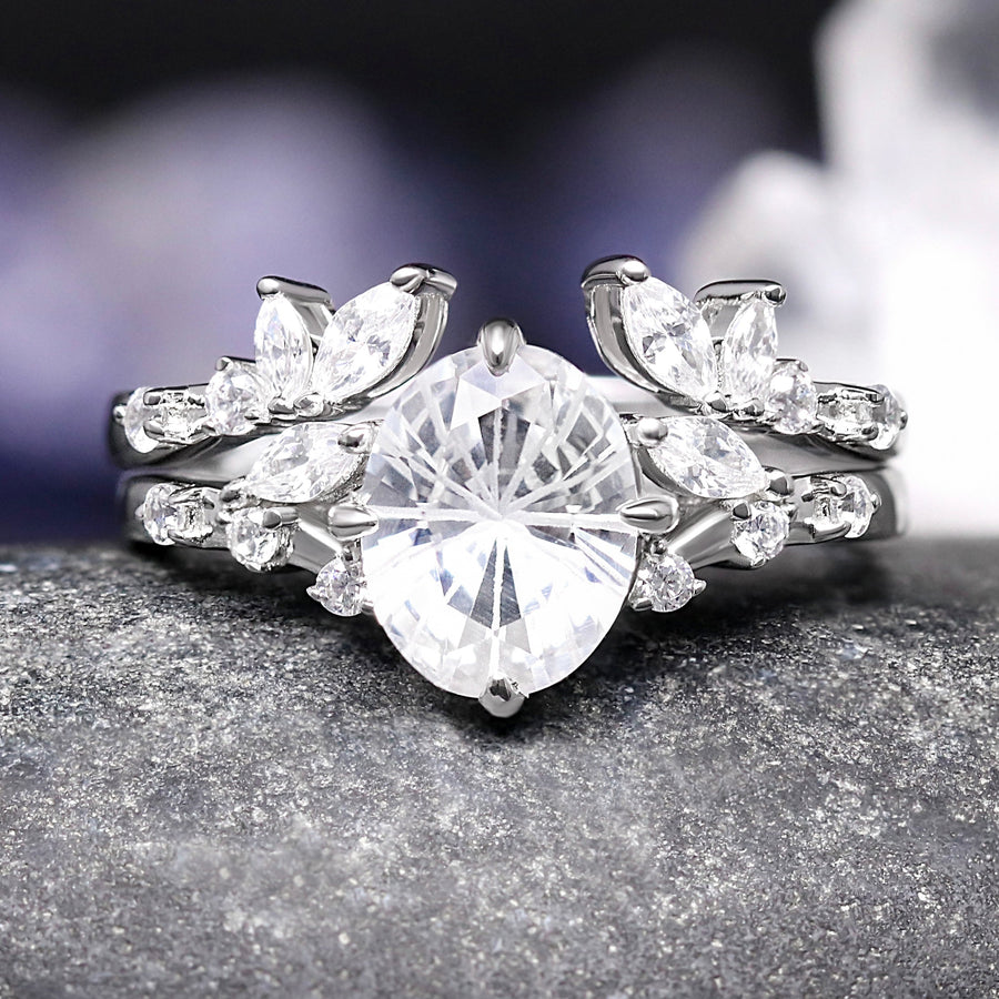 Silver ring with a large central diamond and smaller diamonds on a dark surface