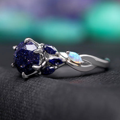 Women's sterling silver blue sandstone engagement ring with white fire opal accents, angled view