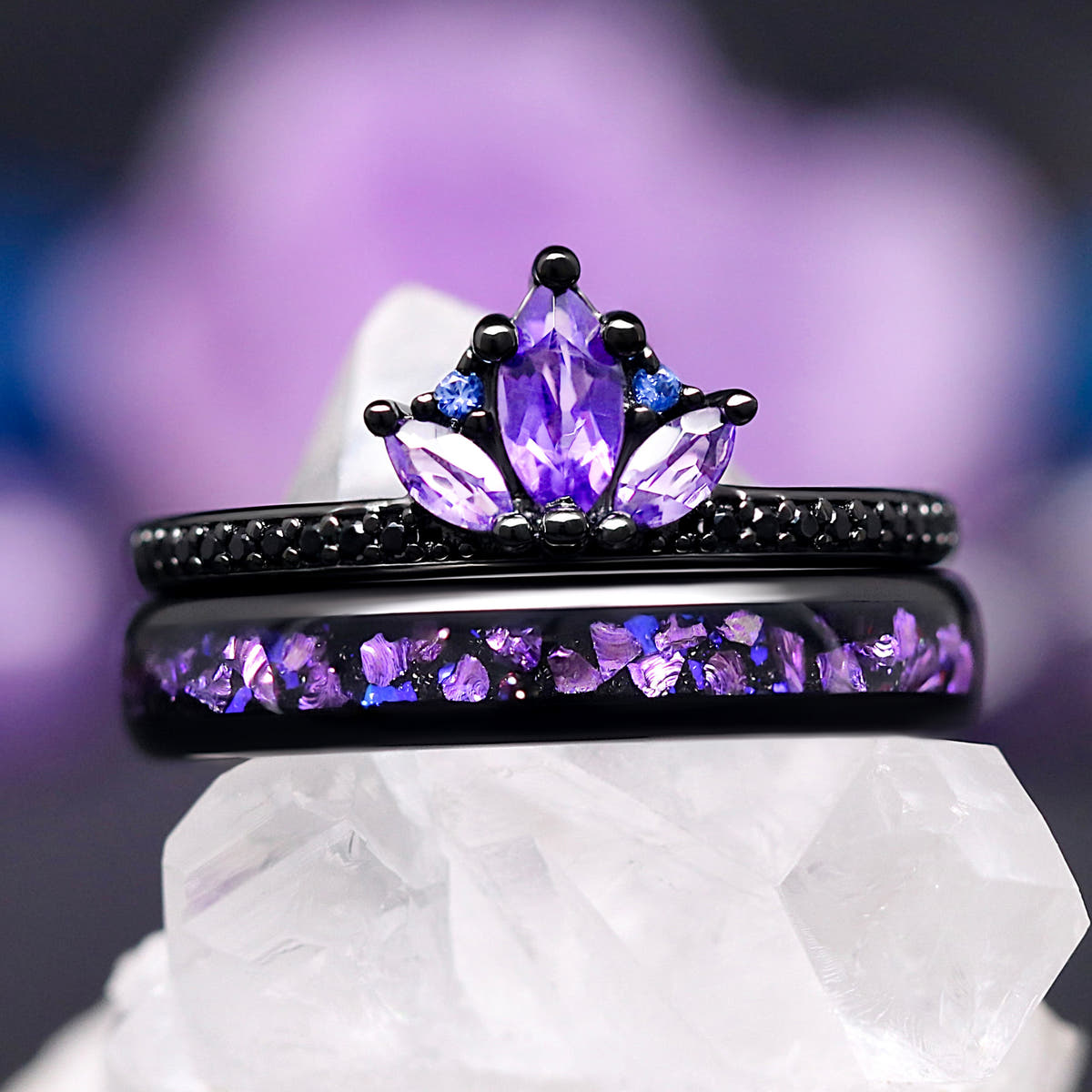 Women's amethyst lotus ring in black sterling silver stacked on a black tungsten band with purple inlay