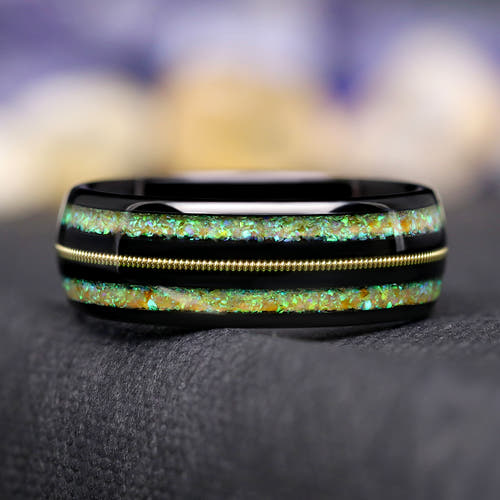 Men's 8mm black tungsten ring with a gold guitar string between two fire opal inlays, front view