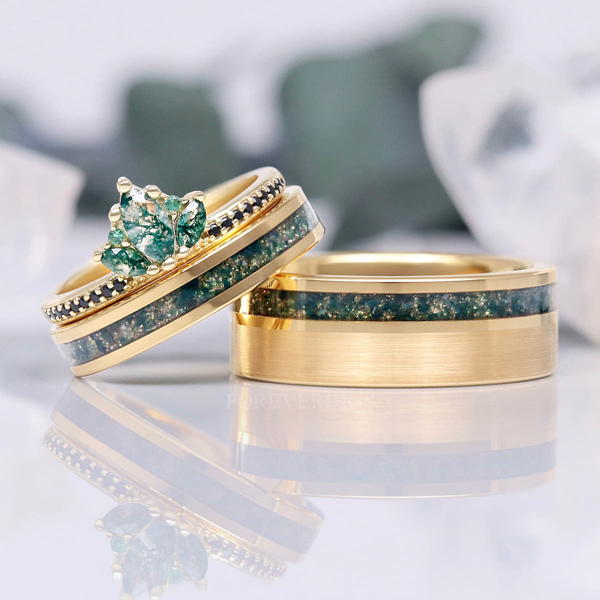 Moss agate crown ring and inlay band leaning on a wider brushed gold band