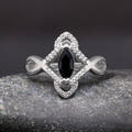 Women's sterling silver marquise black stone ring with a halo of white stones, straight on