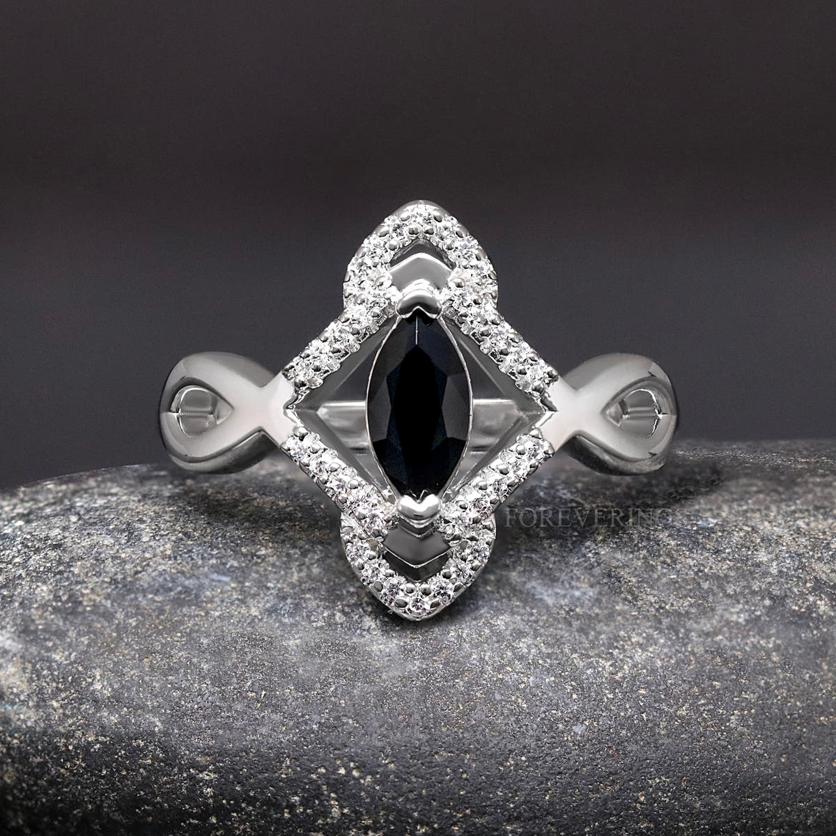 Women's sterling silver marquise black stone ring with a halo of white stones, straight on