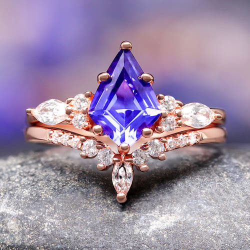 Women's rose gold sterling silver bridal set with a kite-cut sapphire and curved band, close-up