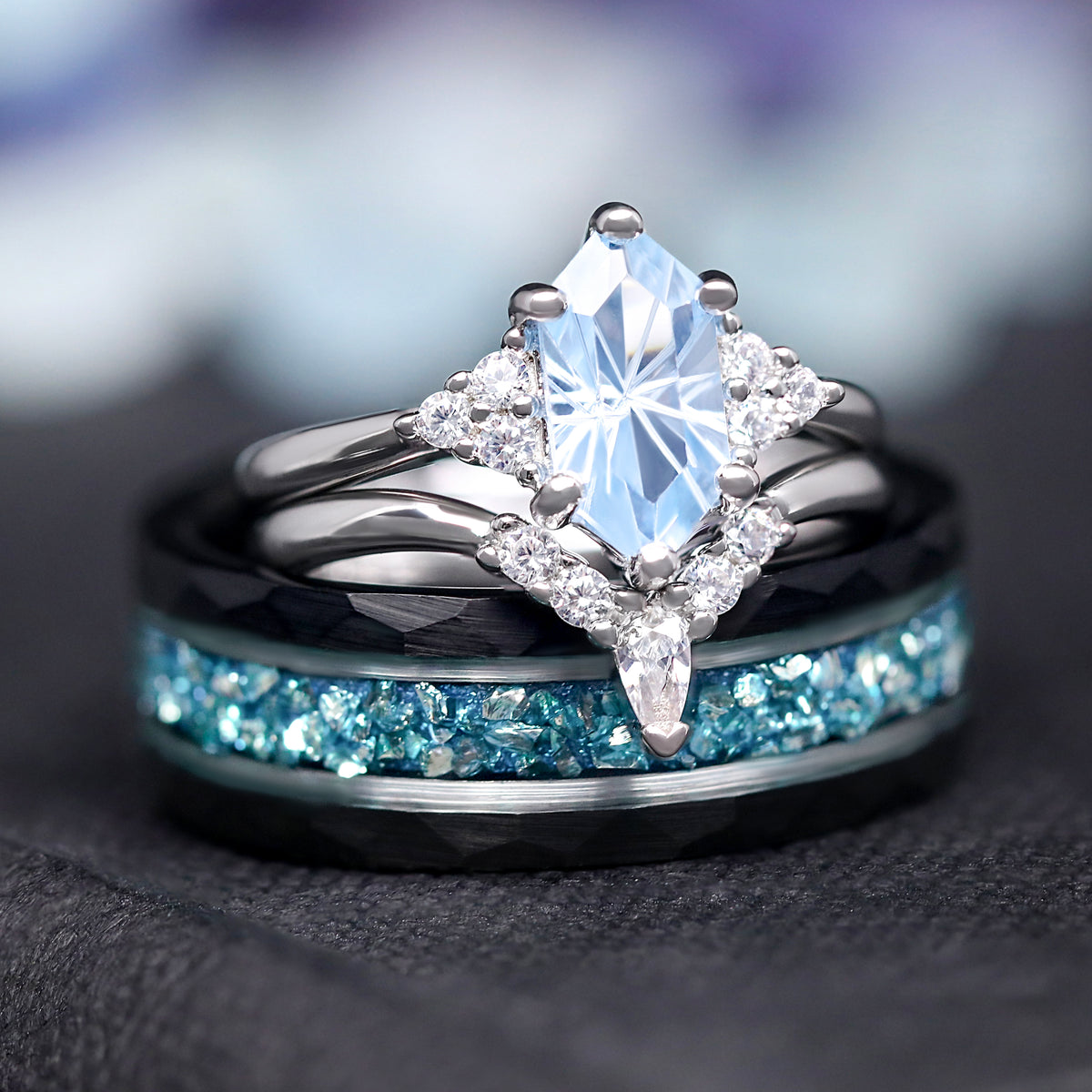 His and hers wedding ring set with the aquamarine bridal set standing in front of the black tungsten band