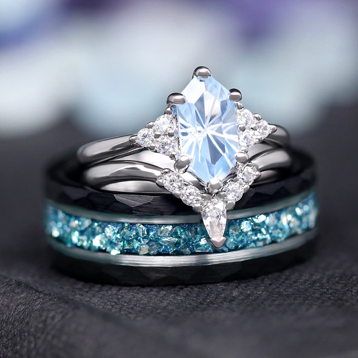 Aquamarine bridal set resting on a wider black hammered band with blue crushed inlay