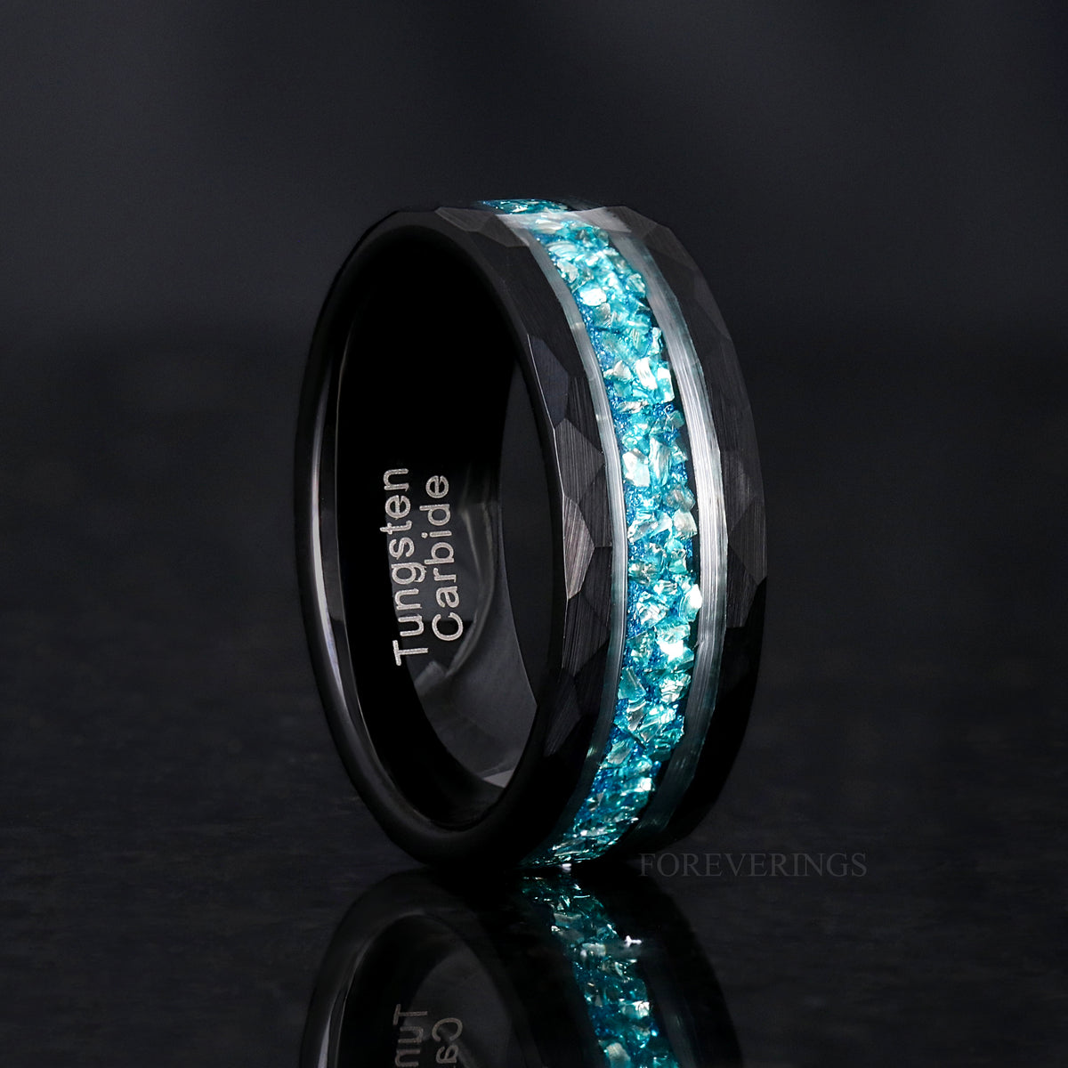 Men's 8mm black faceted tungsten band with crushed aquamarine inlay, standing upright