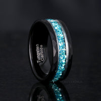 Men's 8mm black faceted tungsten band with crushed aquamarine inlay, standing upright