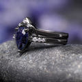 Angled view of the blue sandstone engagement ring and curved band, showing the black setting
