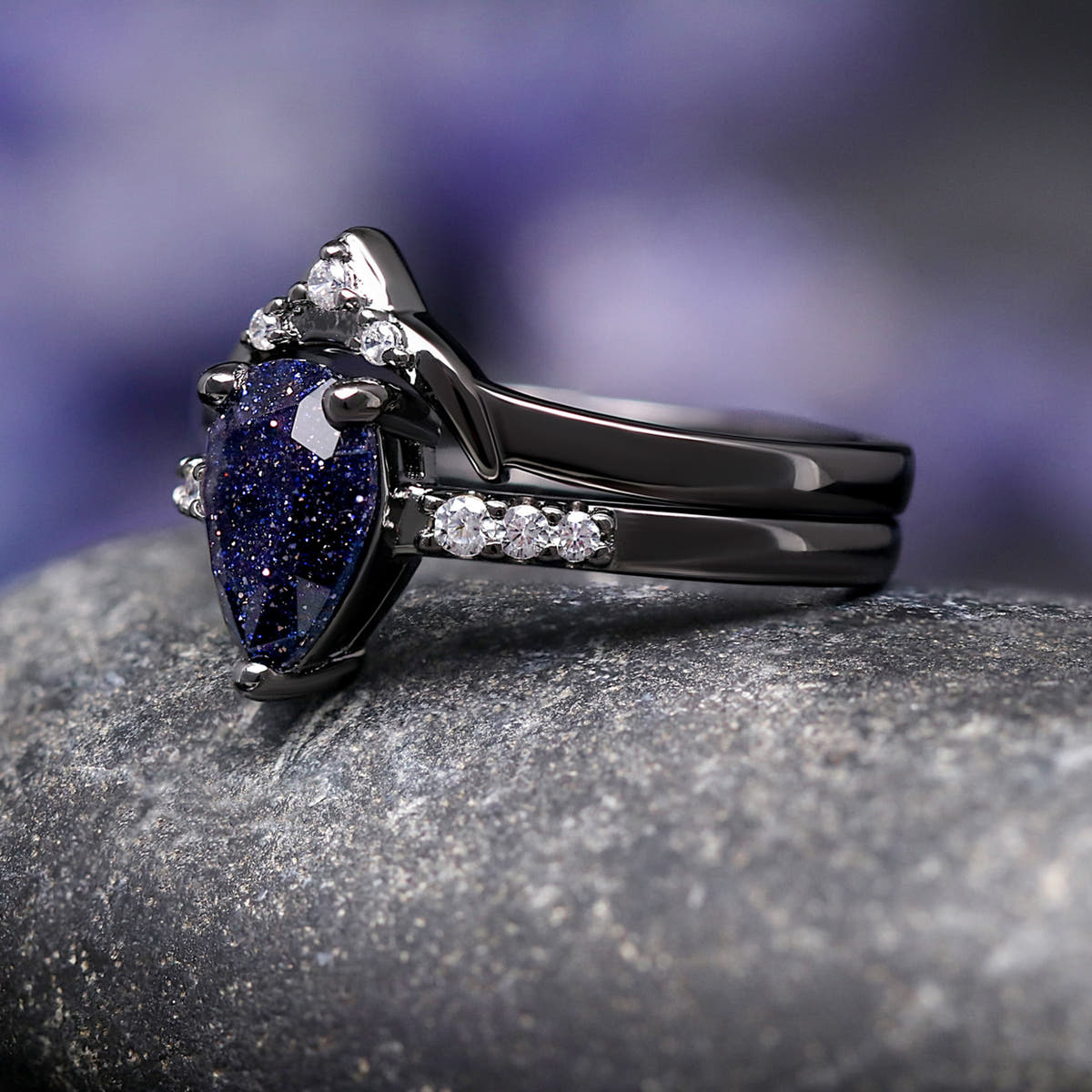 Angled view of the blue sandstone engagement ring and curved band, showing the black setting