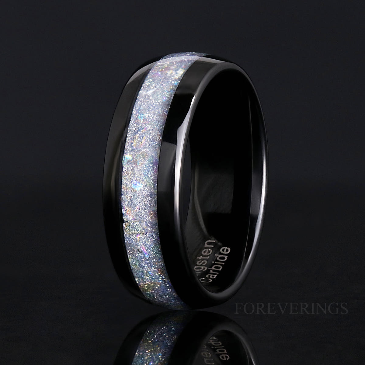 Men's 8mm black tungsten ring with crushed moonstone inlay, standing at an angle