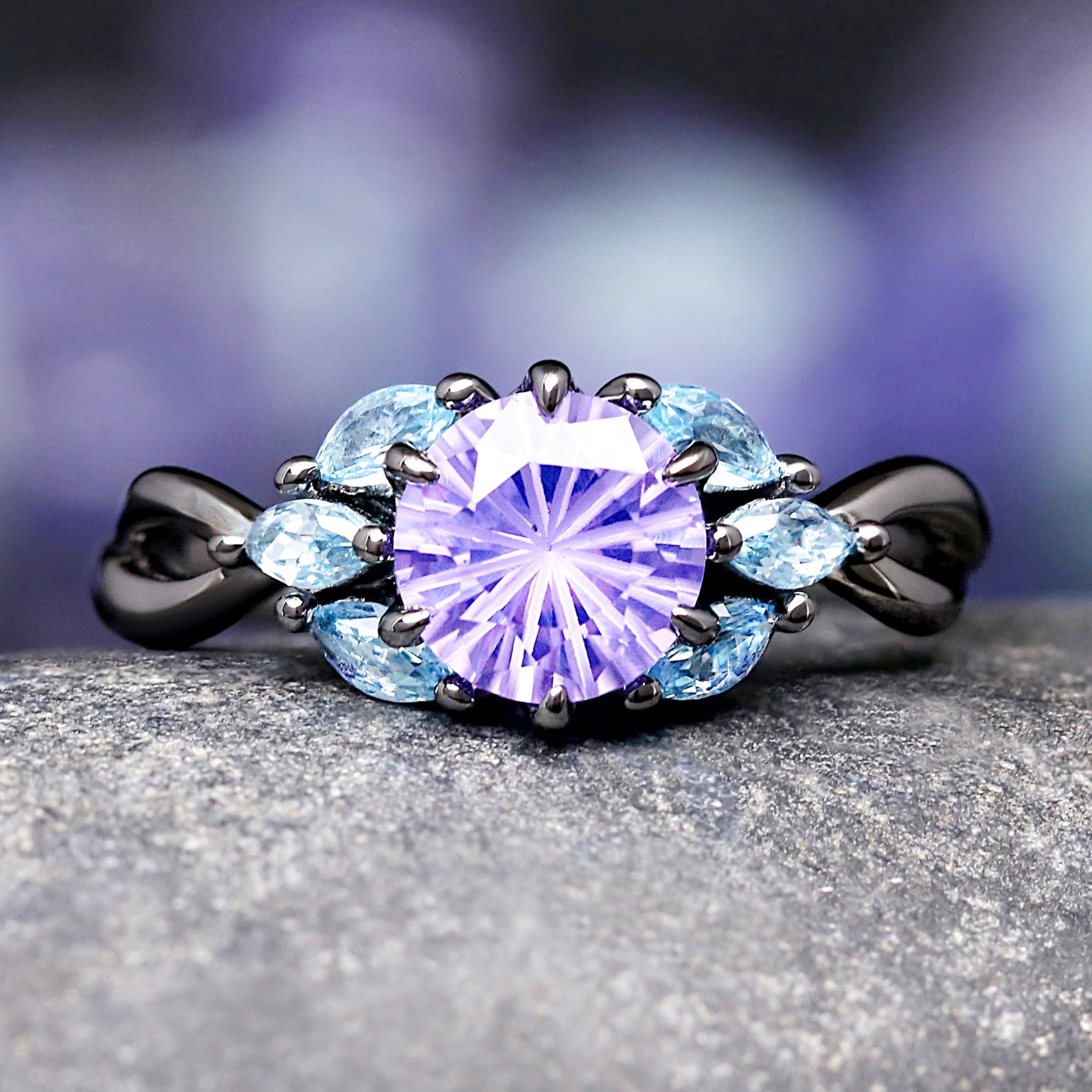 Black ring with a purple amethyst and blue aquamarine.