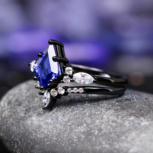 Angled side view of the blue sapphire engagement ring and curved band, white marquise side stones