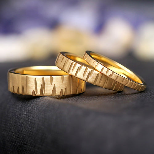 Geared gold tungsten wedding bands in 6mm, 4mm and 2mm widths, lined up leaning on each other