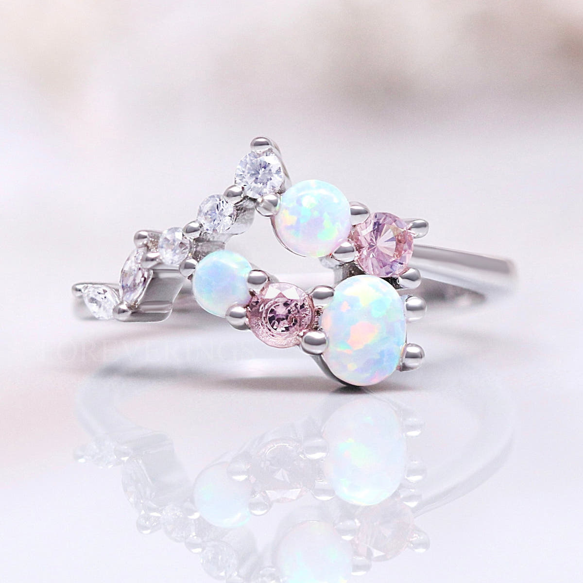 Women's sterling silver cluster ring with white opals and pink morganite, angled front view