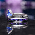 Sapphire lotus ring resting on a silver nebula inlay band, angled side view
