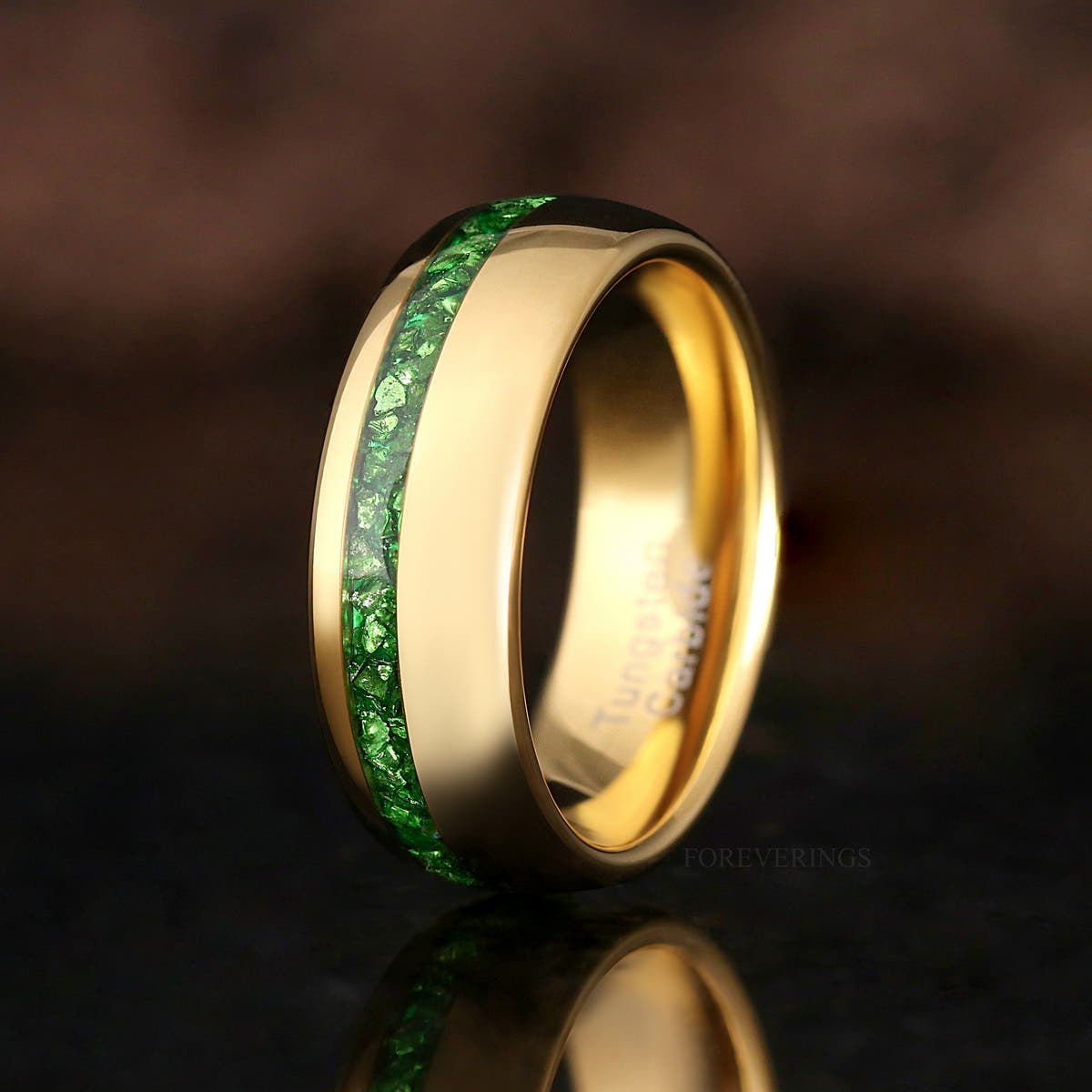 8mm gold tungsten ring with offset emerald inlay, standing and angled in a wider view
