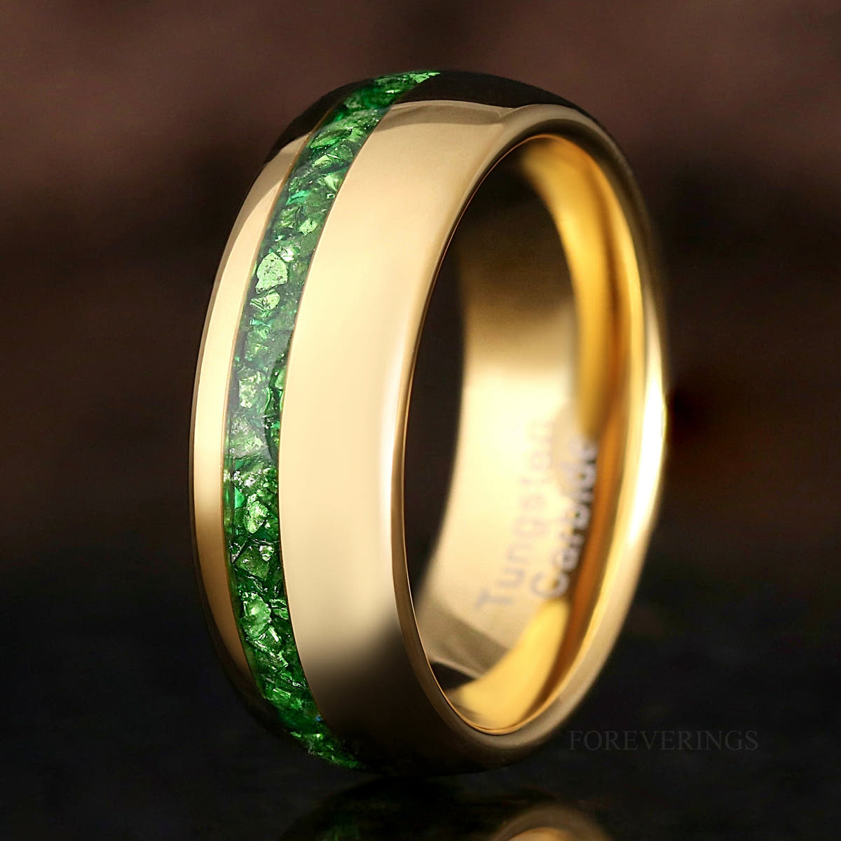 Men's 8mm gold tungsten wedding band with an offset crushed emerald inlay, close-up