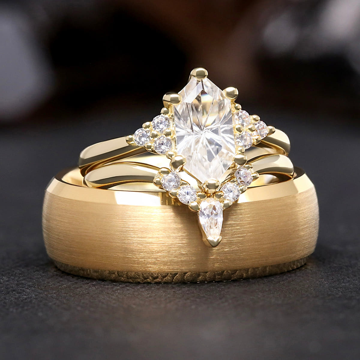 Matching gold couples ring set, white sapphire engagement ring and curved band on an 8mm tungsten band