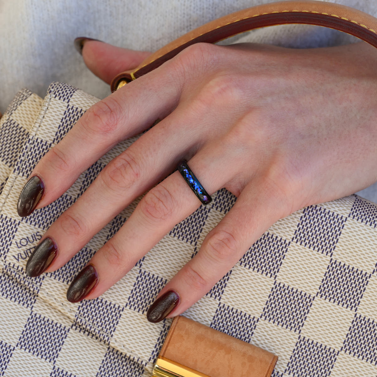 4mm black tungsten nebula band worn on a woman's hand