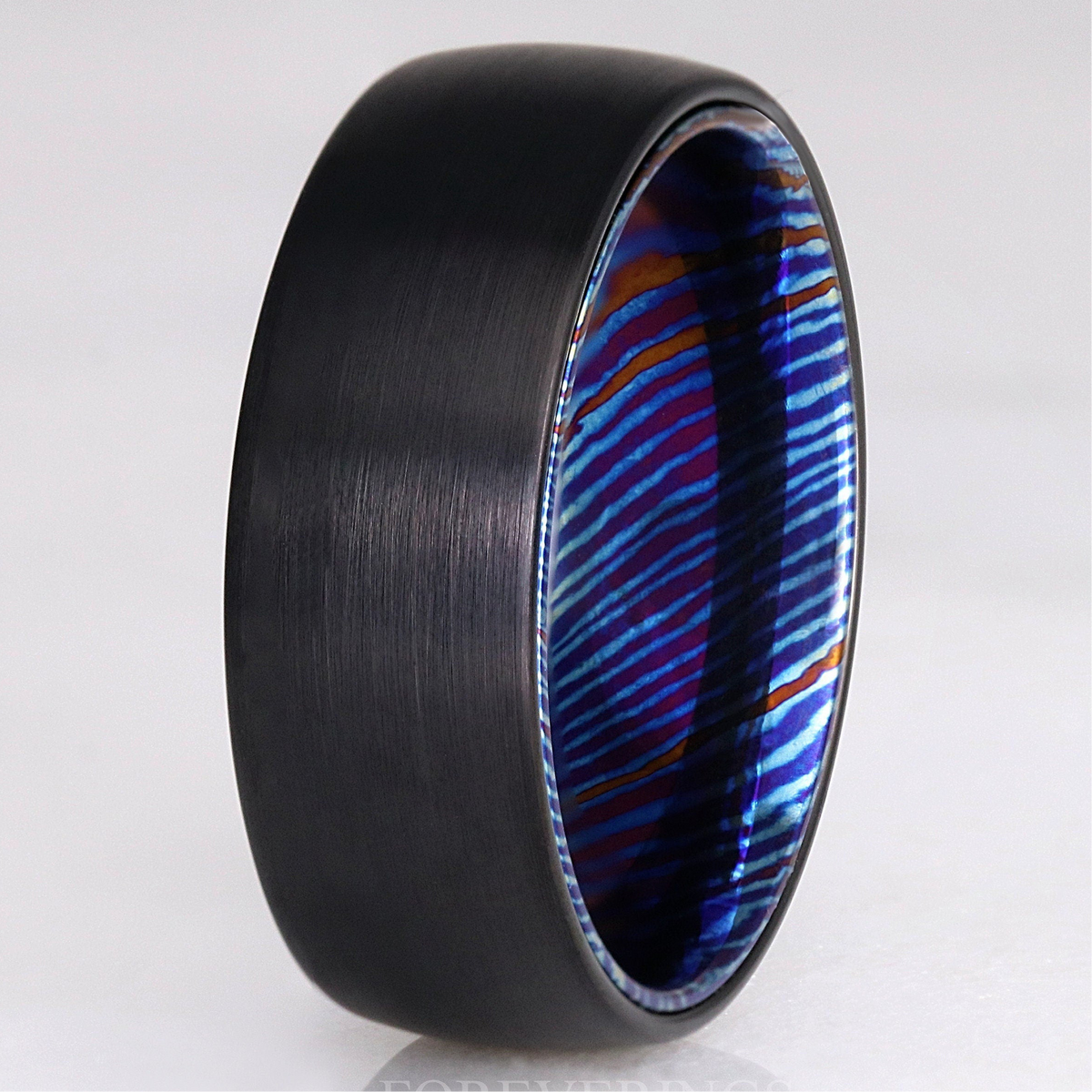Men's 8mm brushed black tungsten wedding band with a blue Timascus sleeve inside