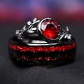 His and hers wedding ring set, the rhodolite engagement ring resting on top of the black tungsten band