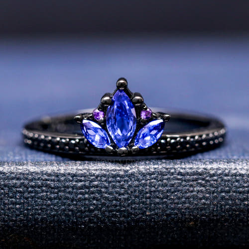 Women's black sterling silver lotus ring with blue sapphire petals and amethyst accents