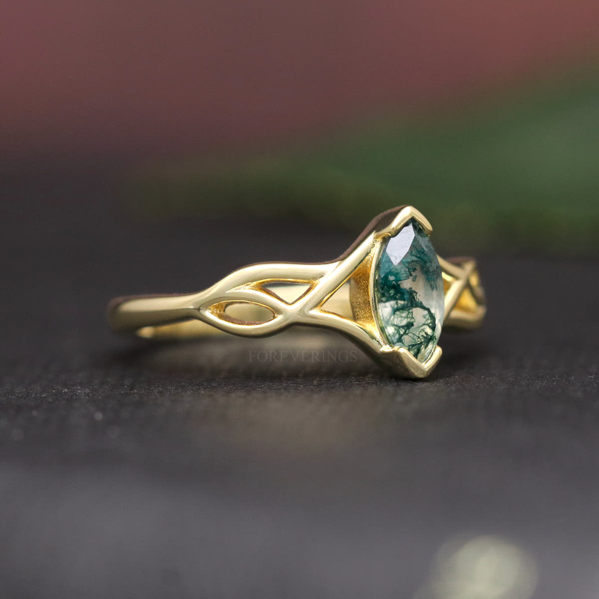 Gold moss agate engagement ring at an angle, side view of the Celtic knot band