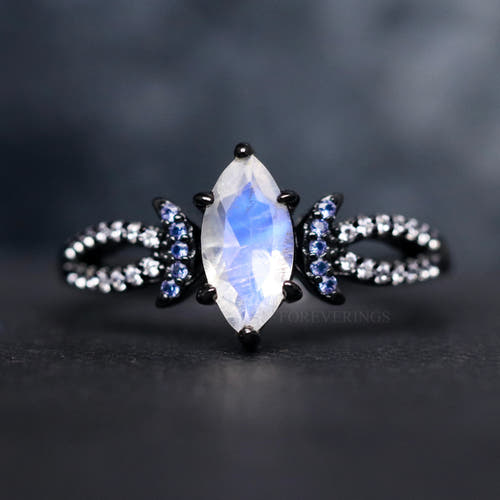 Women's black sterling silver marquise moonstone ring with blue sapphire crescent accents, close crop