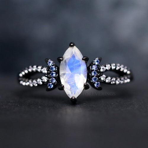 Women's black sterling silver marquise moonstone ring with blue sapphire crescent accents, close crop