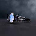 Side view of the black marquise moonstone ring showing the split band with white stones