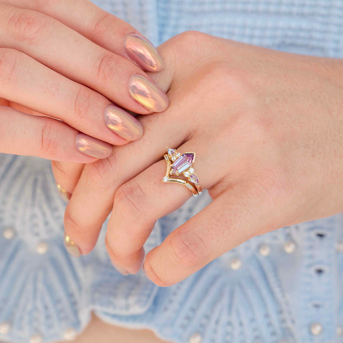 Women's gold alexandrite engagement ring worn on a hand