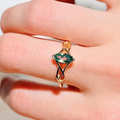 Women's gold marquise moss agate engagement ring worn on a hand