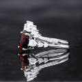Black fire opal bridal set from the side, showing the curved band of pear-shaped clear stones
