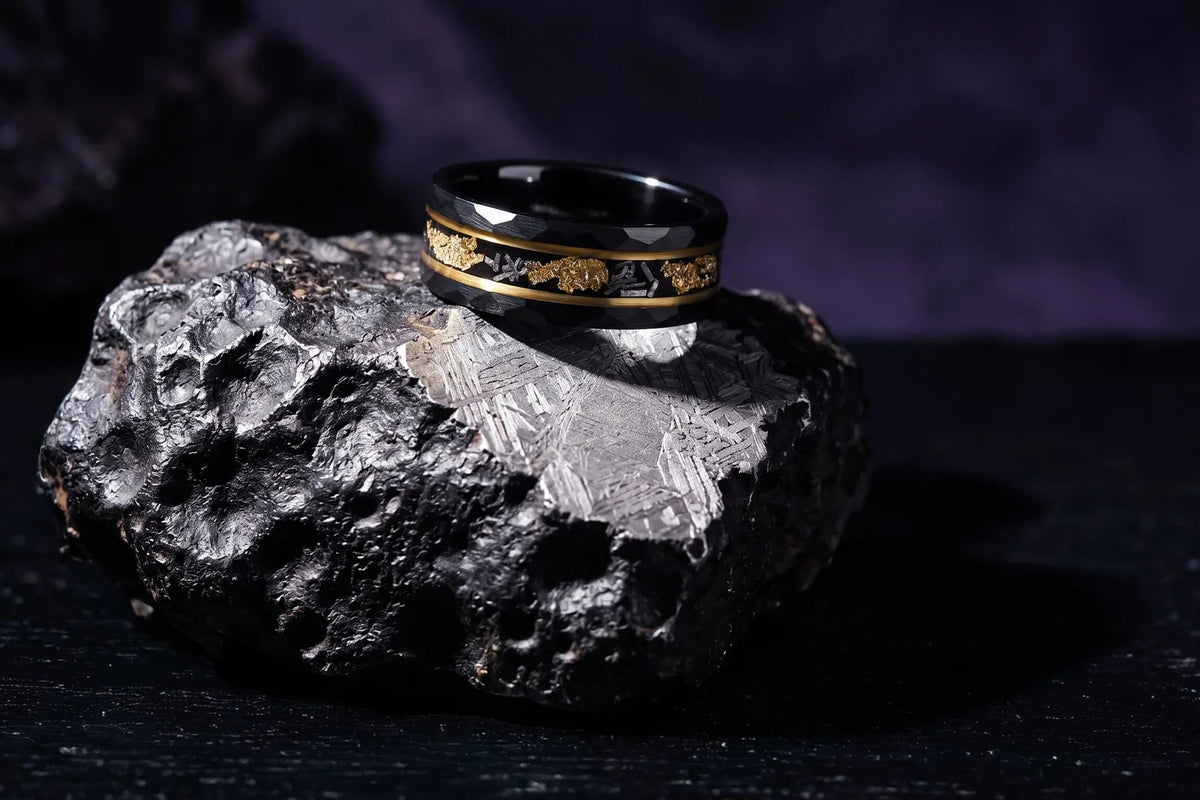 Black and gold meteorite ring on a meteorite slab