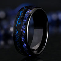 Men's 8mm black tungsten band with crushed blue sapphire and blue foil inlays, standing at an angle