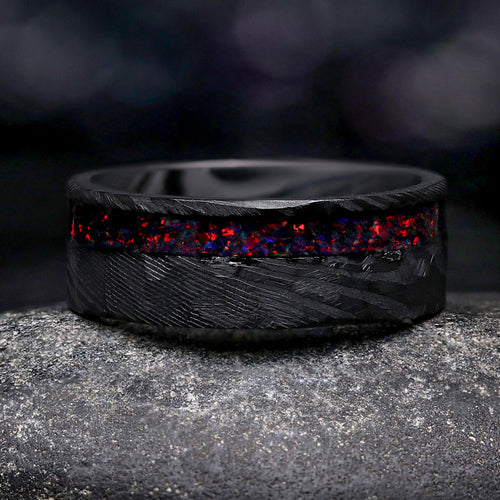 Men's 8mm hammered black Damascus steel wedding band with an offset black fire opal inlay
