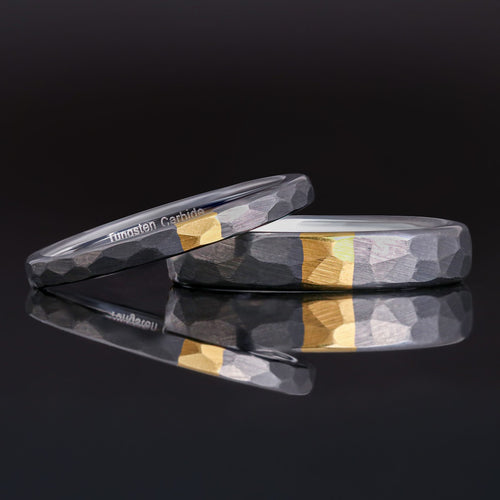 2mm and 4mm hammered silver tungsten bands with a gold strip, the thin one leaning on the wider